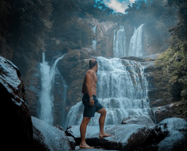 Man facing a waterfall